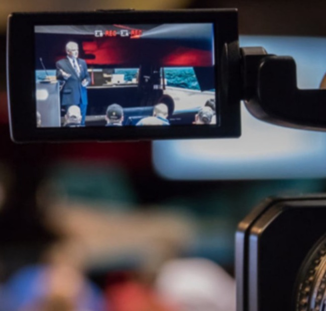Event speaker presentation filmed at Kalamazoo Air Zoo, F-14 Tomcat aircraft in background – business video and photography by Imaginarium Pictures