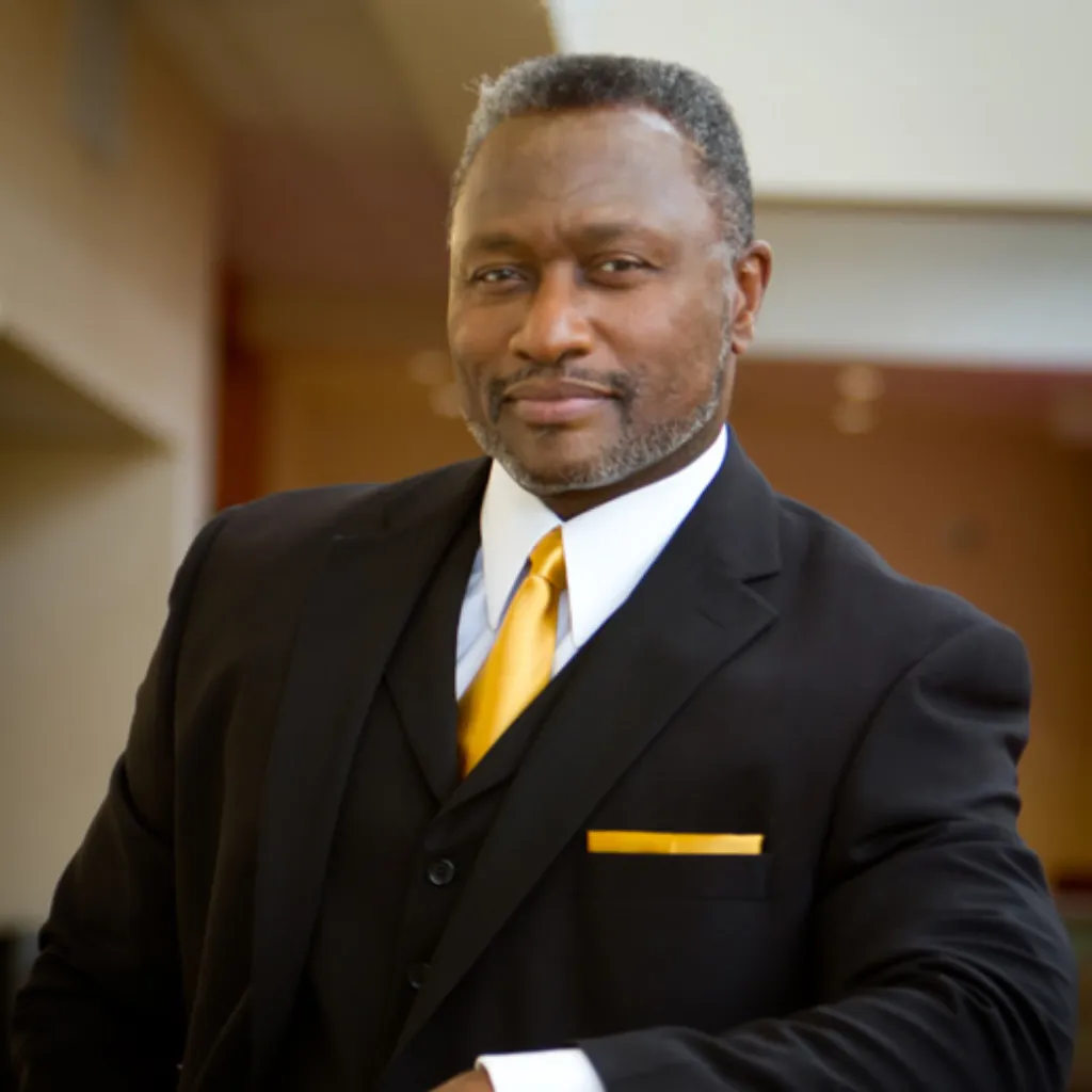 Executive headshot of man in black suit and gold tie – Imaginarium Pictures professional portraits